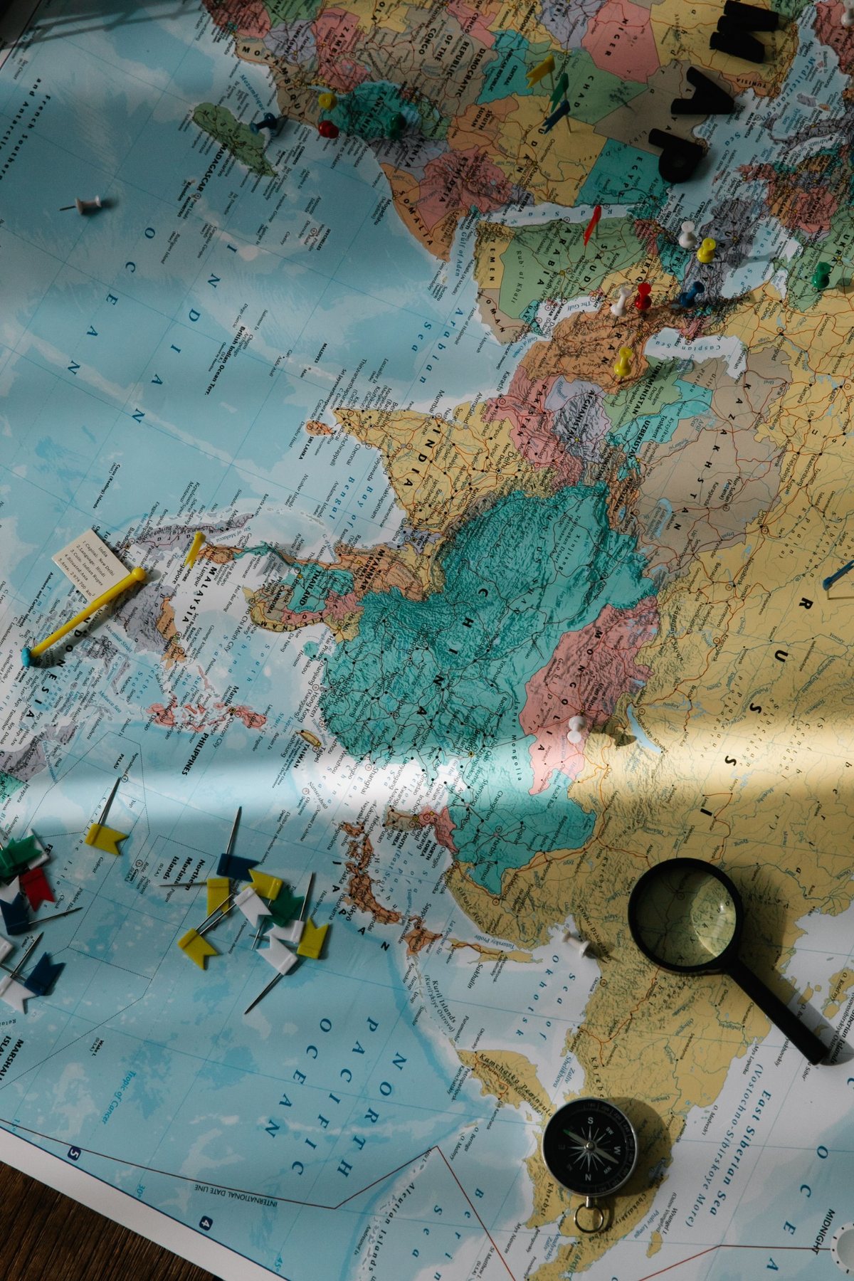 World map with pins and compass